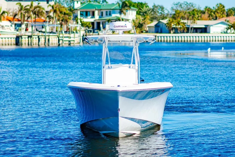  Yacht Photos Pics 2015 Invincible 33 Open Fisherman boat on calm water near coastal homes.