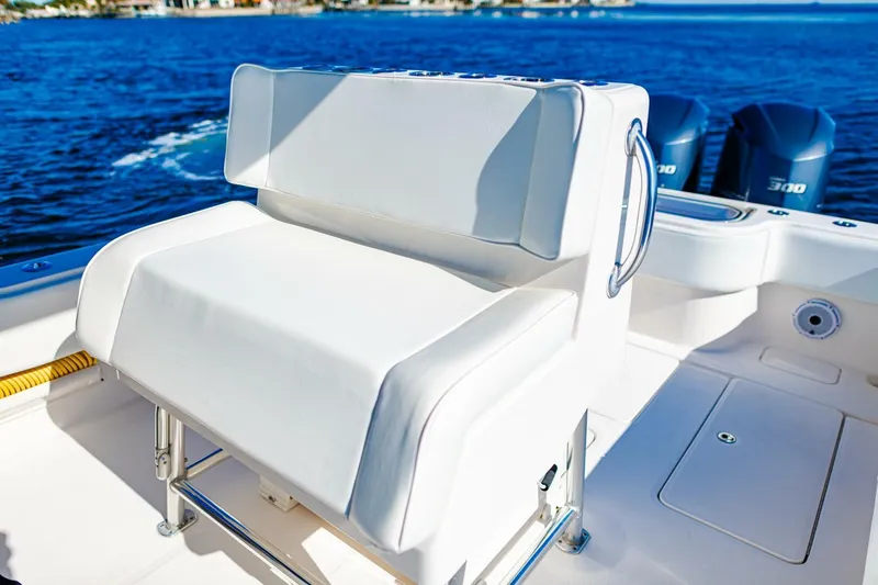  Yacht Photos Pics Invincible 33 Open Fisherman 2015 boat with white seating and dual engines on blue water.