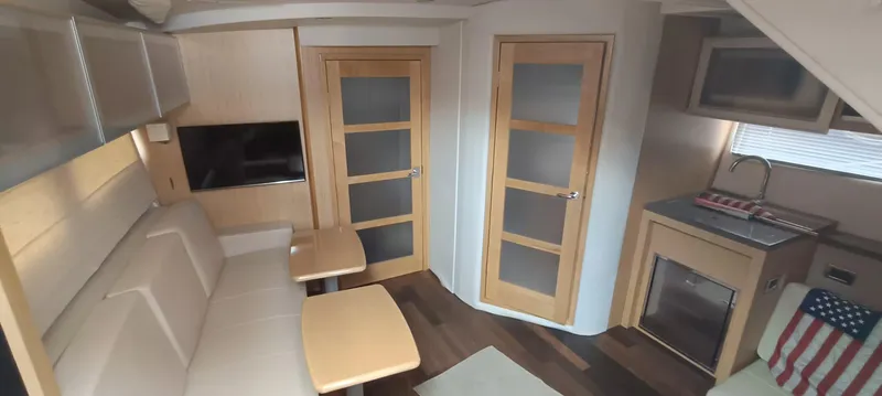 2016 Four Winns H440 Yacht Photos Pics Interior of 2016 Four Winns H440 yacht with modern seating, kitchenette, and wooden doors.