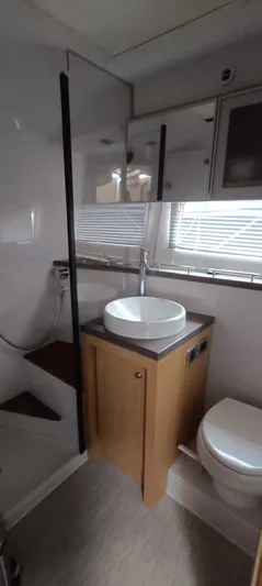 2016 Four Winns H440 Yacht Photos Pics 2016 Four Winns H440 yacht bathroom with modern fixtures and wooden cabinetry.