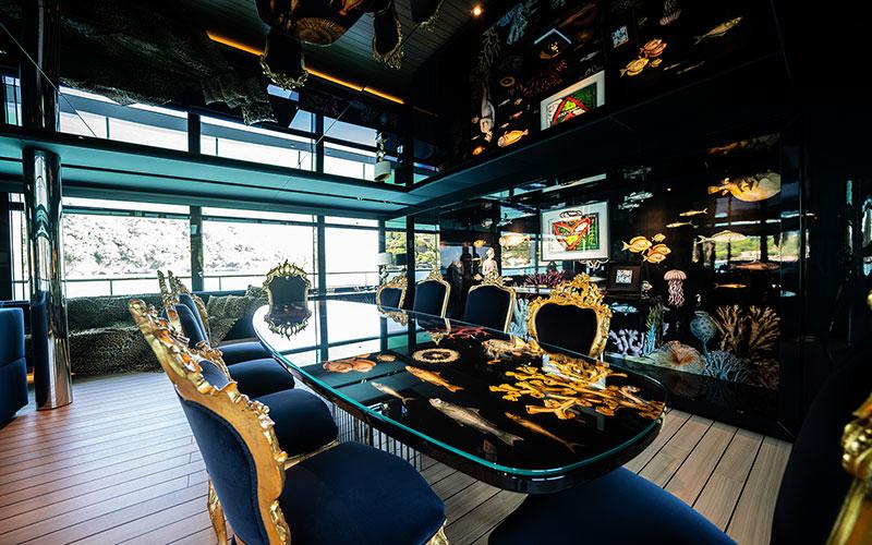 Luxurious Codecasa F74 yacht interior with elegant dining area, ornate chairs, and marine-themed decor, 2019.