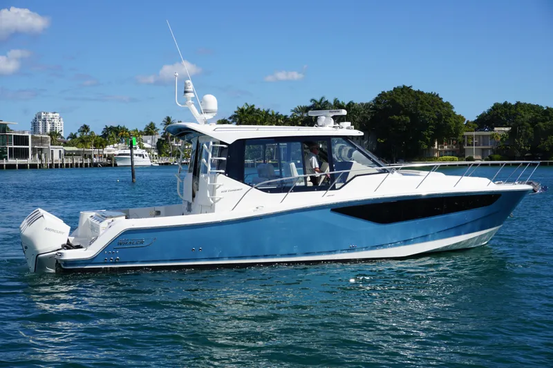 Rendezvous Yacht Photos Pics 2021 Boston Whaler 405 Conquest boat cruising on clear blue water.