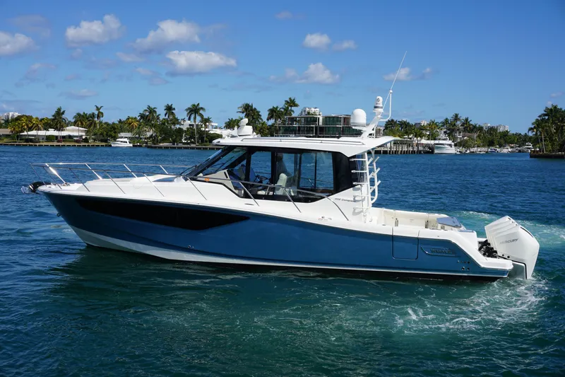 Rendezvous Yacht Photos Pics 2021 Boston Whaler 405 Conquest cruising on a sunny day with palm trees in the background.