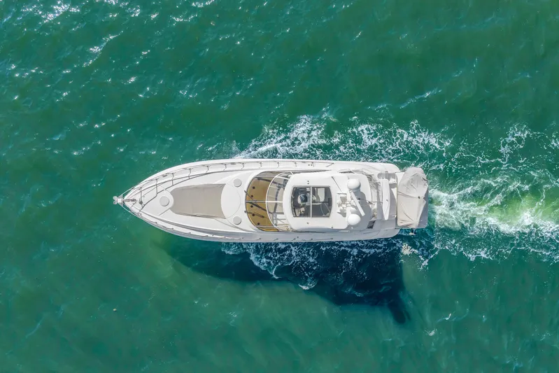  Yacht Photos Pics Aerial view of 2002 Cruisers 5370 yacht cruising on turquoise water.