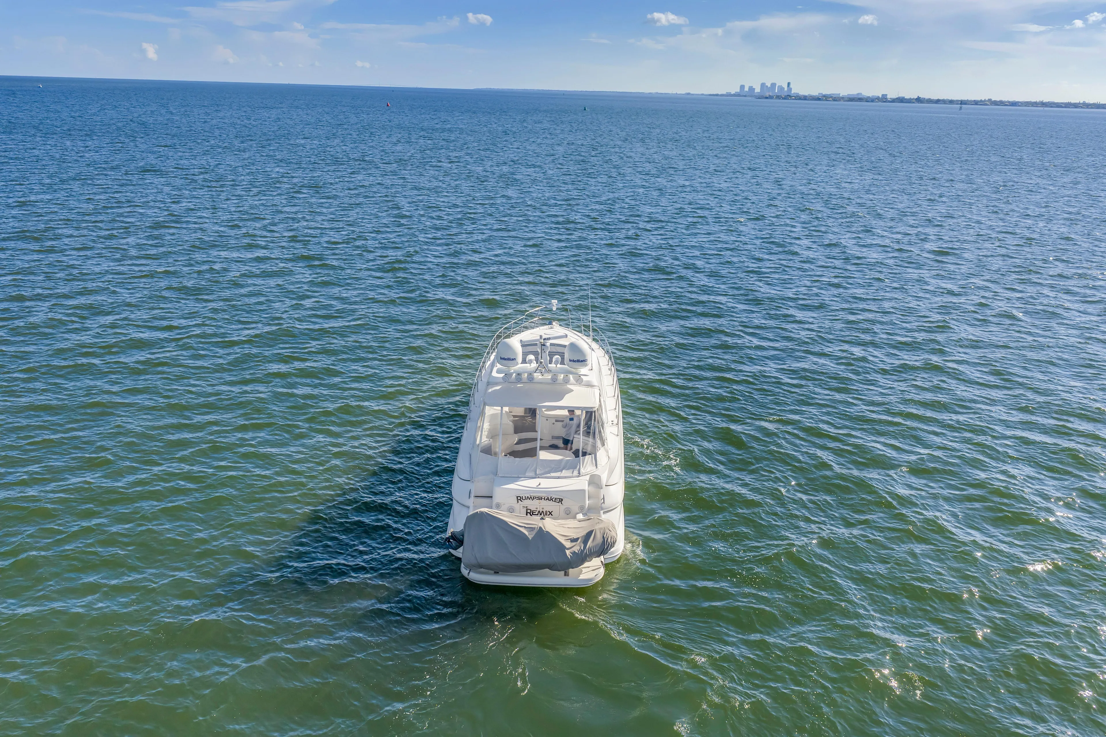  Yacht Photos Pics 2002 Cruisers 5370 yacht on open water with distant city skyline.