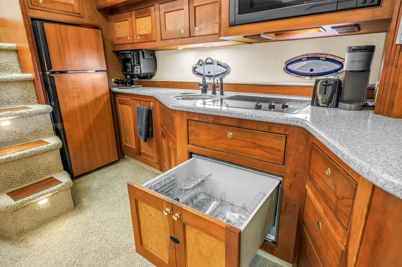  Yacht Photos Pics Luxurious 2002 Cruisers 5370 yacht kitchen with wood cabinetry, dishwasher, and modern appliances.