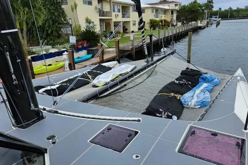 Vandal Yacht Photos Pics Gunboat 55 catamaran docked, showcasing deck and rigging, with waterfront homes in the background.