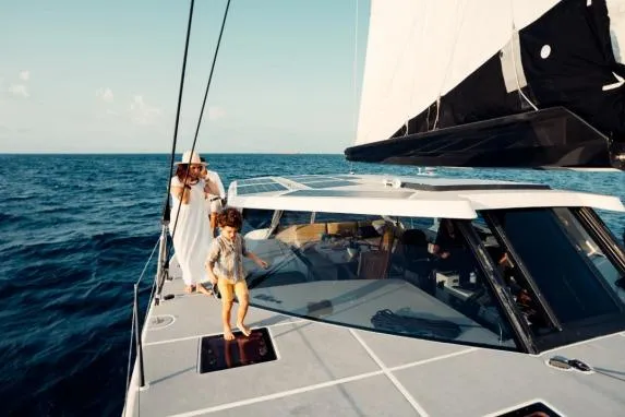 Vandal Yacht Photos Pics Family enjoying a sunny day on a 2014 Gunboat 55 catamaran sailing in open waters.