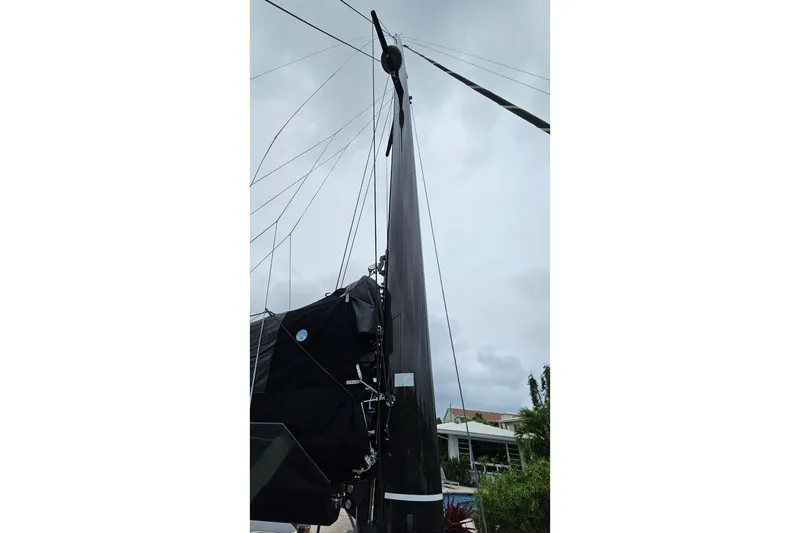 Vandal Yacht Photos Pics Mast of 2014 Gunboat 55 sailboat against cloudy sky, showcasing rigging details.
