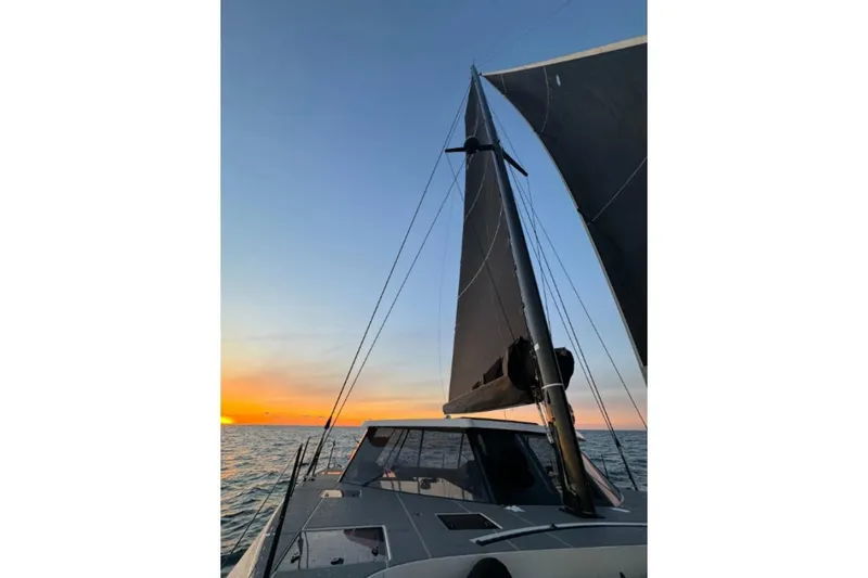 Vandal Yacht Photos Pics Sailing Gunboat 55 at sunset, 2014 model, with vibrant sky and ocean view.