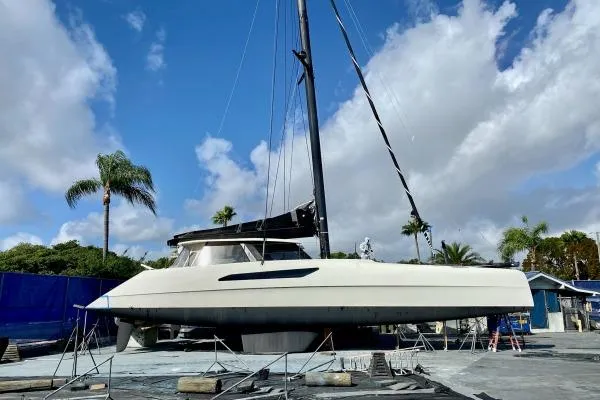 Vandal Yacht Photos Pics 2014 Gunboat 55 catamaran on land, blue sky, palm trees in background.