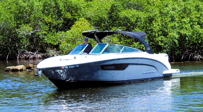Sea M.a.j.i.c. Yacht Photos Pics 2022 Regal 33 OBX boat cruising on a calm river with lush greenery.