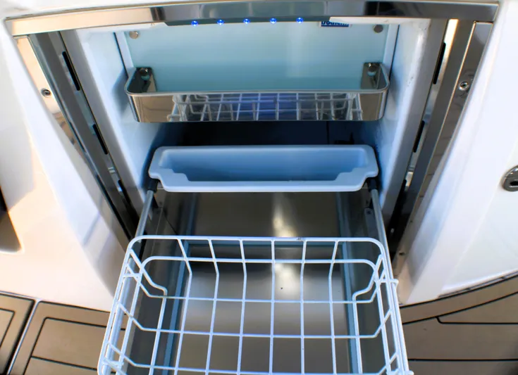 Sea M.a.j.i.c. Yacht Photos Pics 2022 Regal 33 OBX boat refrigerator with open compartments and wire basket.