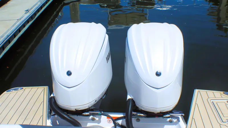 Sea M.a.j.i.c. Yacht Photos Pics Twin outboard engines on a 2022 Regal 33 OBX boat docked by the water.