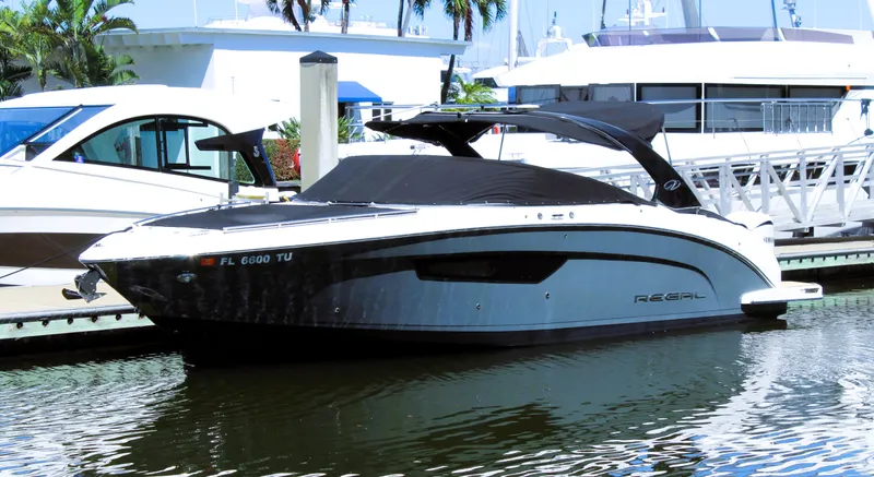 Sea M.a.j.i.c. Yacht Photos Pics 2022 Regal 33 OBX boat docked at marina, sleek design, black and white color scheme.