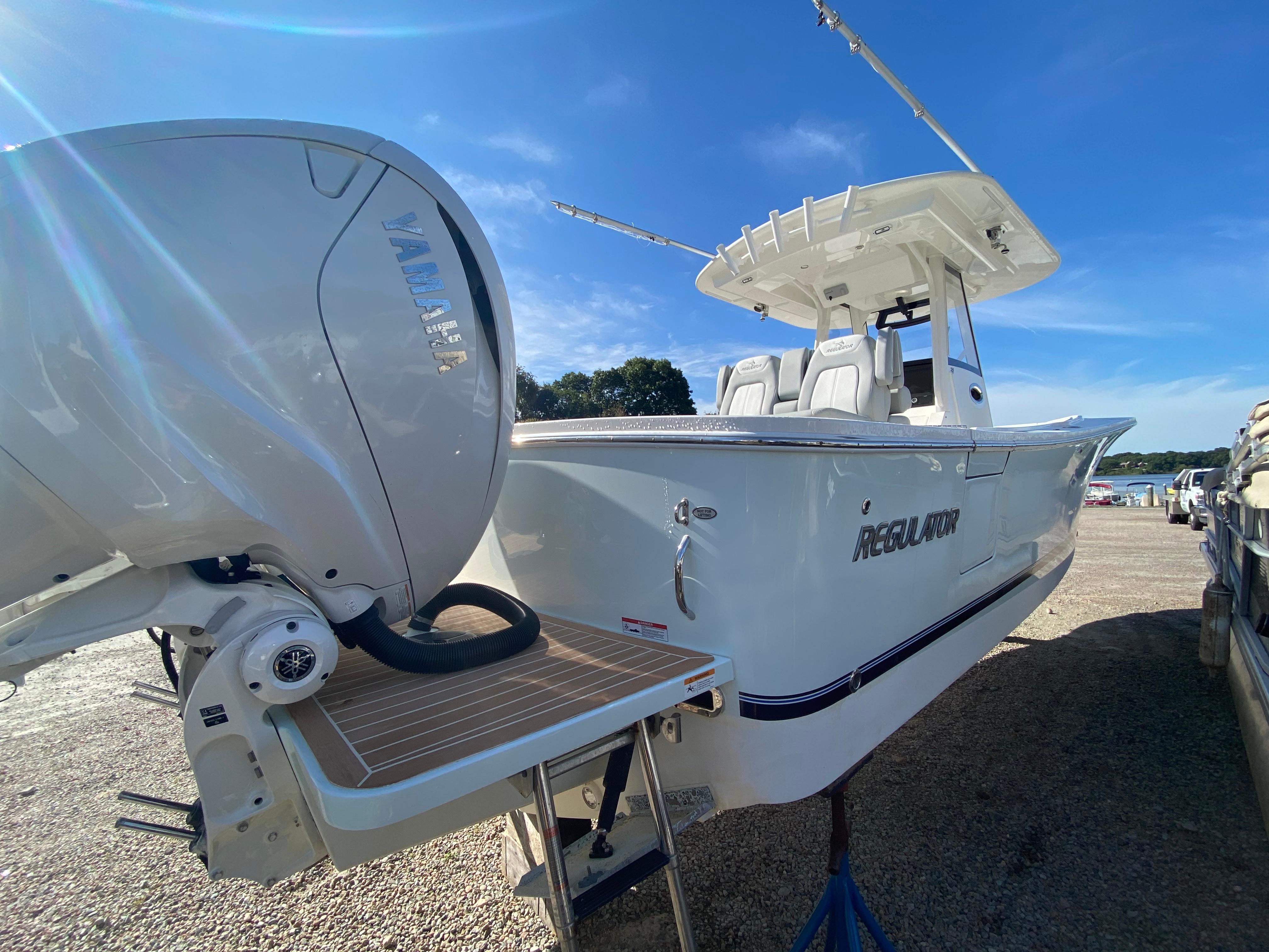 2022 Regulator 31 boat with Yamaha engine, docked under clear blue sky.