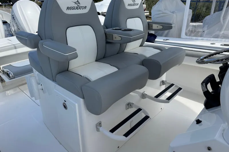  Yacht Photos Pics 2022 Regulator 31 boat with dual gray and white captain's chairs, armrests, and footrests.