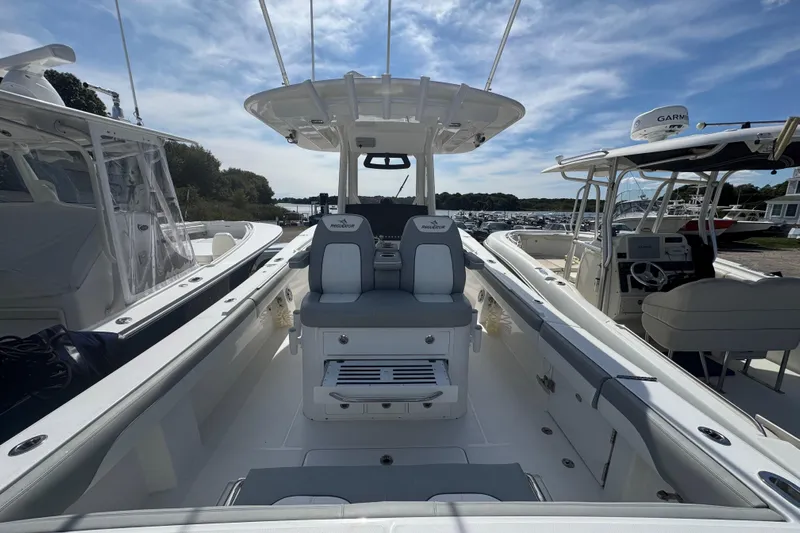  Yacht Photos Pics 2022 Regulator 31 boat interior with seating and helm, docked under a blue sky.
