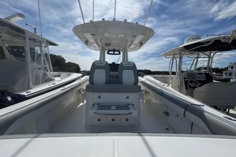  Yacht Photos Pics 2022 Regulator 31 boat interior with seating and console under a blue sky.