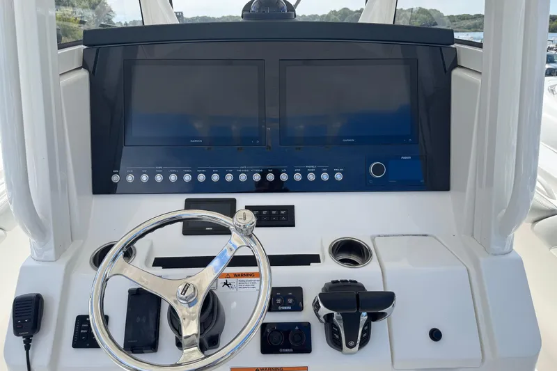  Yacht Photos Pics 2022 Regulator 31 boat dashboard with dual screens, steering wheel, and controls.