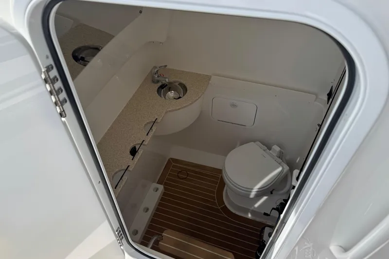  Yacht Photos Pics 2022 Regulator 31 boat interior with compact bathroom, featuring a toilet and sink.