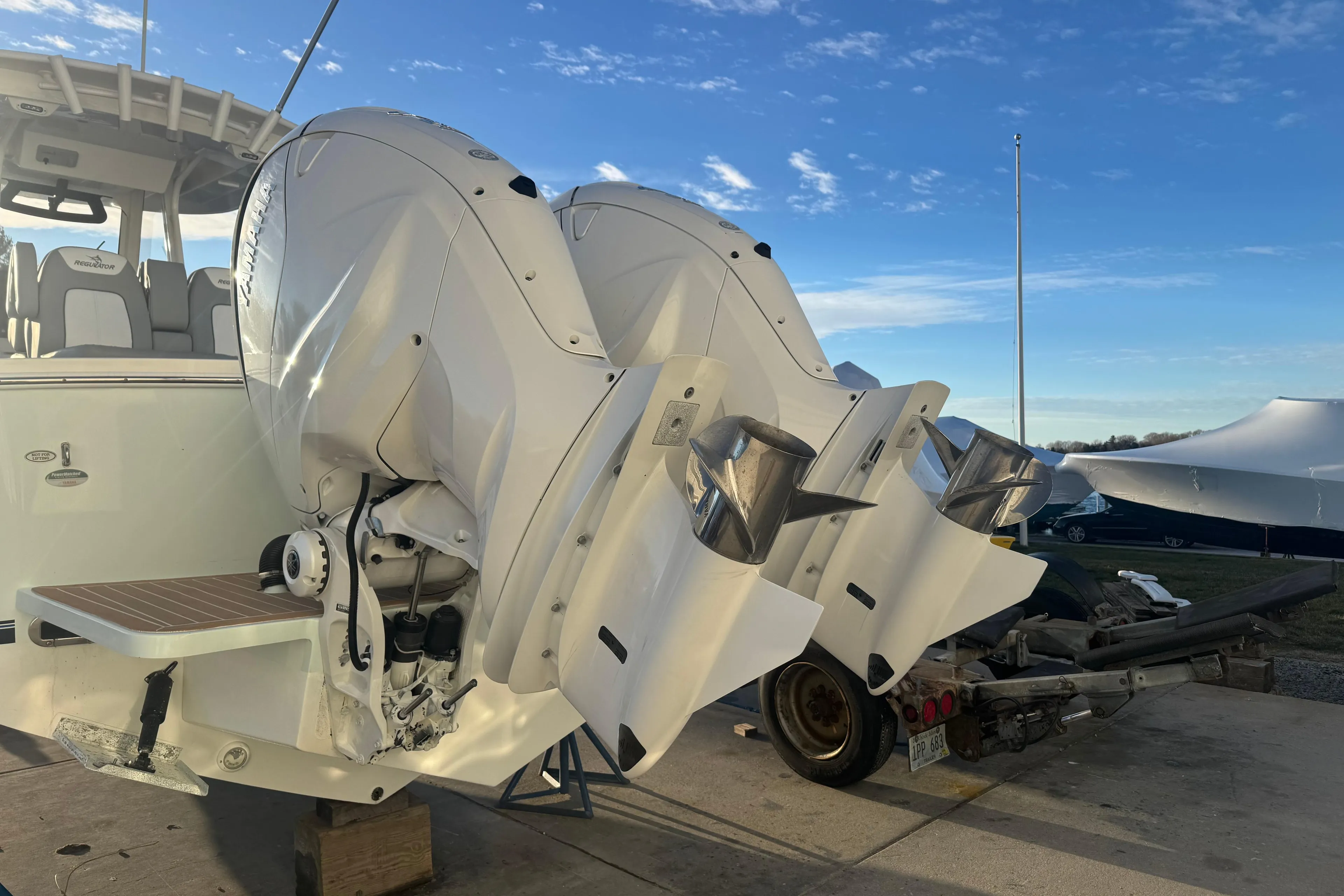 2022 Regulator 31 boat with dual outboard engines on a trailer under a clear sky.
