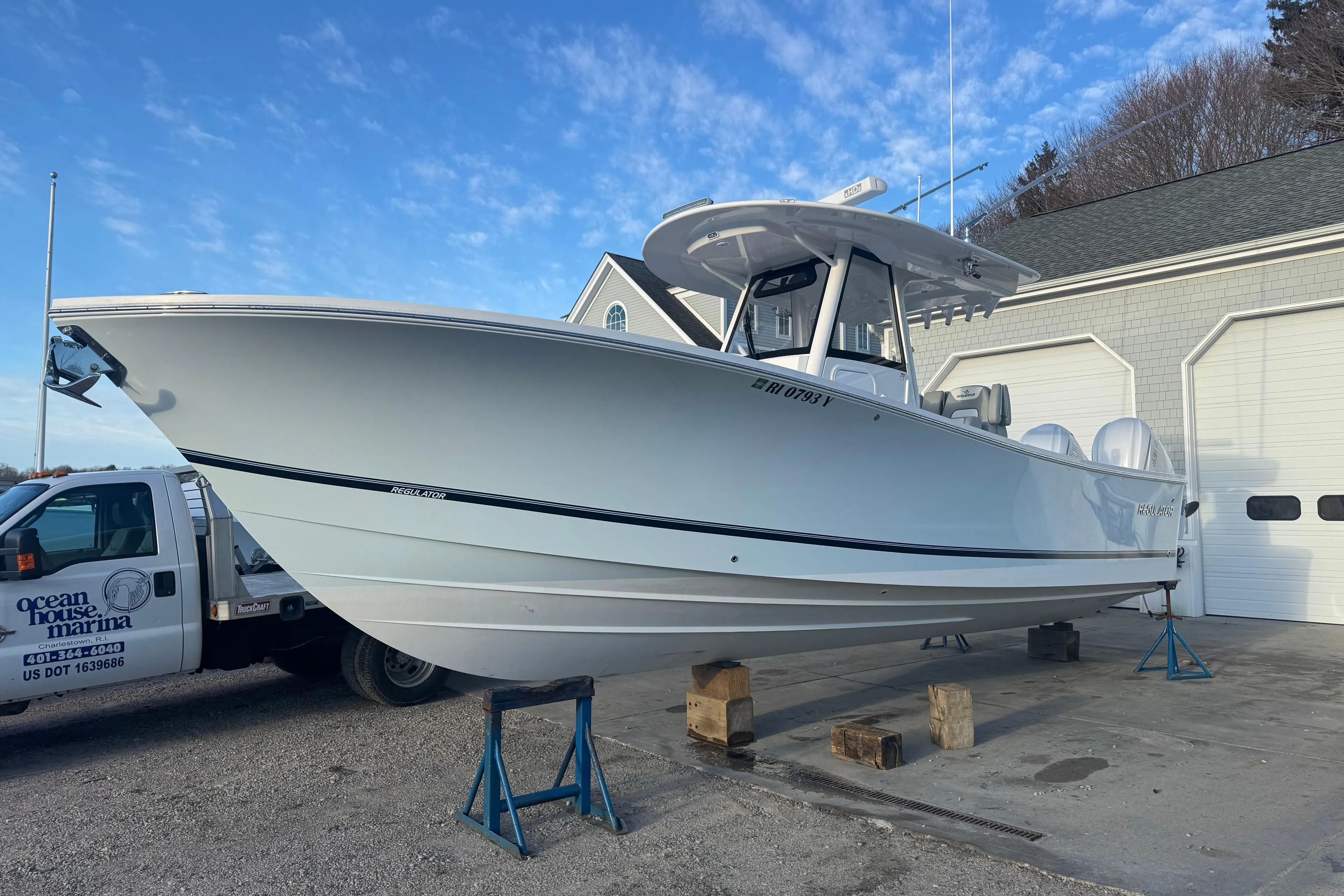2022 Regulator 31 boat on blocks outside marina building under blue sky.