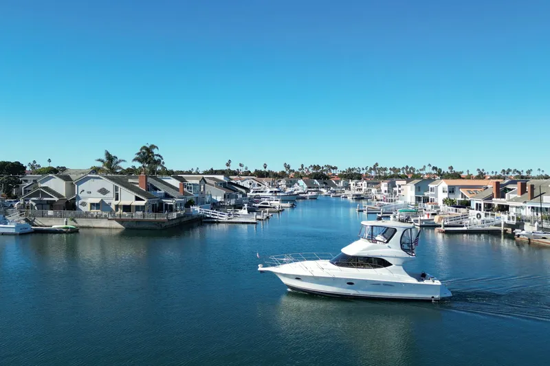 Reelin N Rockin Yacht Photos Pics 2003 Silverton 38 Convertible yacht cruising in a scenic residential marina.