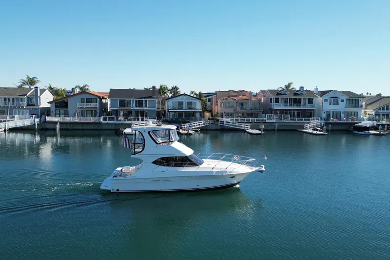 Reelin N Rockin Yacht Photos Pics 2003 Silverton 38 Convertible yacht cruising near waterfront homes.