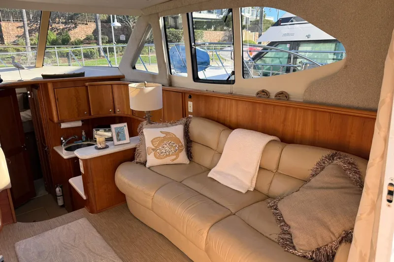 Reelin N Rockin Yacht Photos Pics Interior of 2003 Silverton 38 Convertible yacht with beige leather sofa and wooden cabinetry.