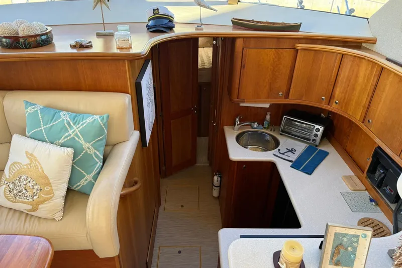 Reelin N Rockin Yacht Photos Pics Interior of 2003 Silverton 38 Convertible yacht with cozy seating and compact kitchen.