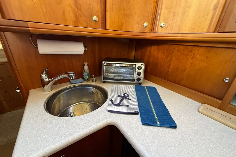 Reelin N Rockin Yacht Photos Pics 2003 Silverton 38 Convertible yacht kitchen with sink, toaster oven, and nautical-themed decor.