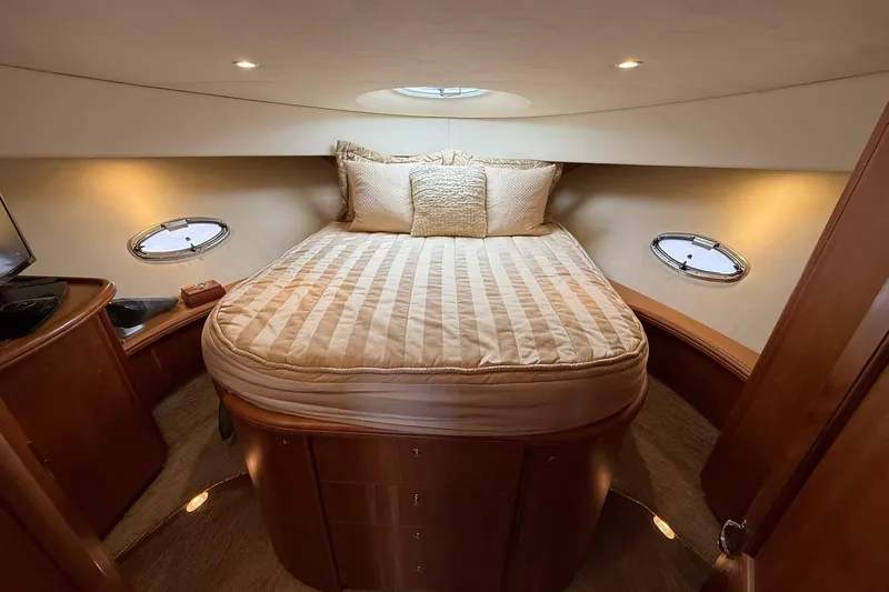 Reelin N Rockin Yacht Photos Pics Luxurious cabin interior of 2003 Silverton 38 Convertible yacht with cozy bed and portholes.