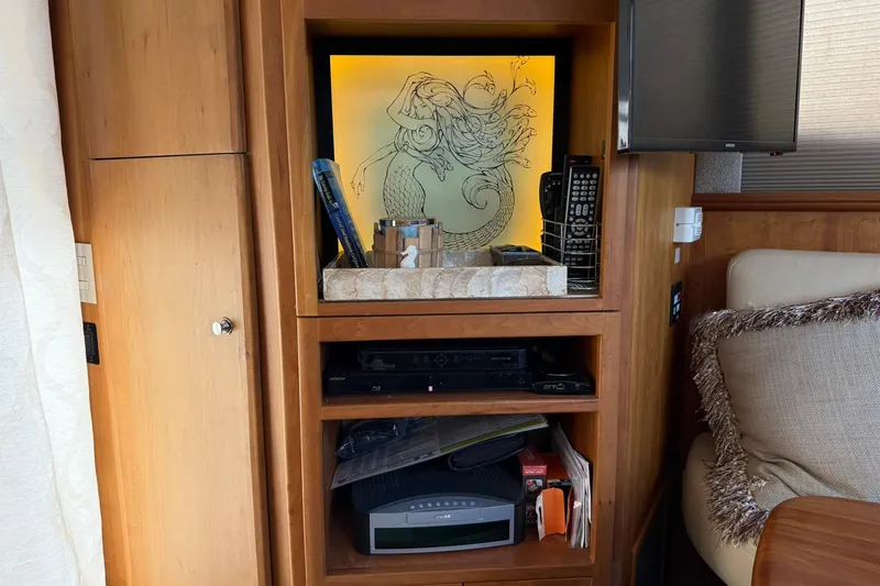 Reelin N Rockin Yacht Photos Pics Interior of 2003 Silverton 38 Convertible with wooden shelves and decorative mermaid artwork.