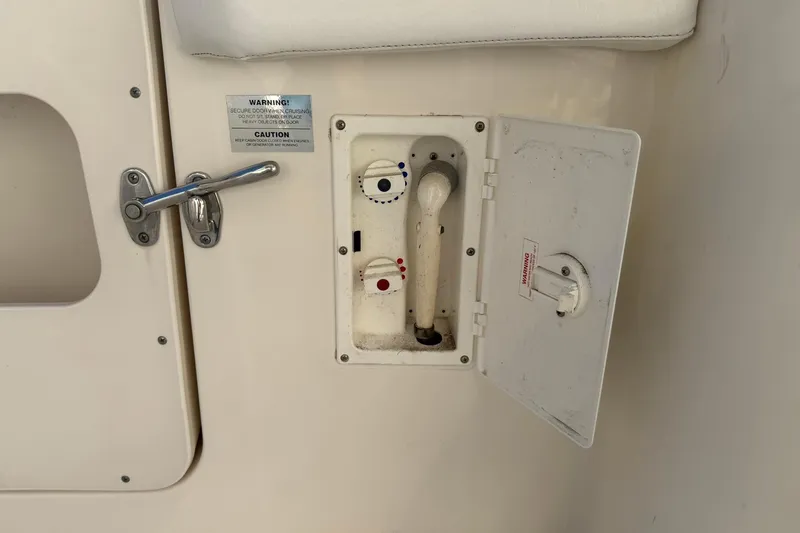 Reelin N Rockin Yacht Photos Pics 2003 Silverton 38 Convertible boat shower compartment with handle and warning labels.