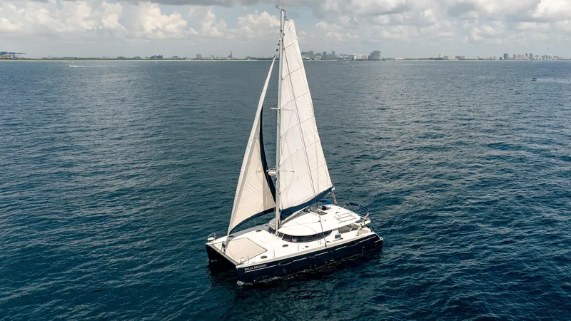 Bellamaggio Yacht Photos Pics Sailing catamaran Fountaine Pajot Salina 48 Evolution, 2008, on open sea with city skyline.