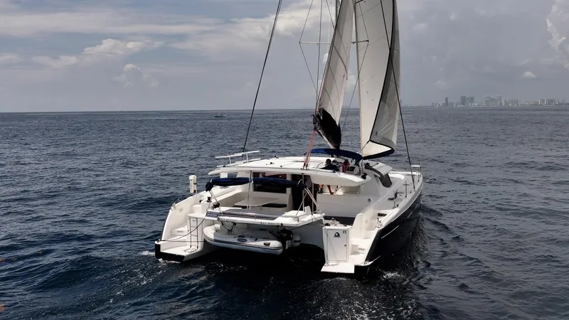 Bellamaggio Yacht Photos Pics Sailing catamaran Fountaine Pajot Salina 48 Evolution, 2008, on open sea with city skyline.