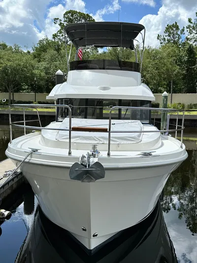 Oceans Edge Yacht Photos Pics 2022 Beneteau Swift Trawler 35 docked, front view, surrounded by trees and blue sky.