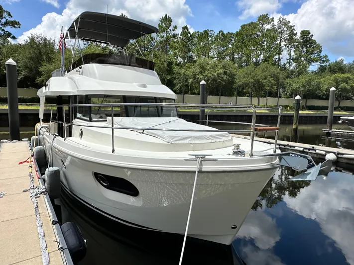 Oceans Edge Yacht Photos Pics 2022 Beneteau Swift Trawler 35 docked at marina, surrounded by trees and calm water.
