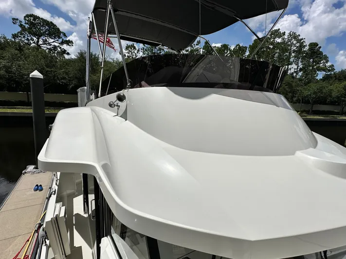 Oceans Edge Yacht Photos Pics 2022 Beneteau Swift Trawler 35 docked, showcasing sleek design and flybridge under a blue sky.