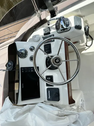 Oceans Edge Yacht Photos Pics Helm of 2022 Beneteau Swift Trawler 35 with steering wheel and navigation controls.