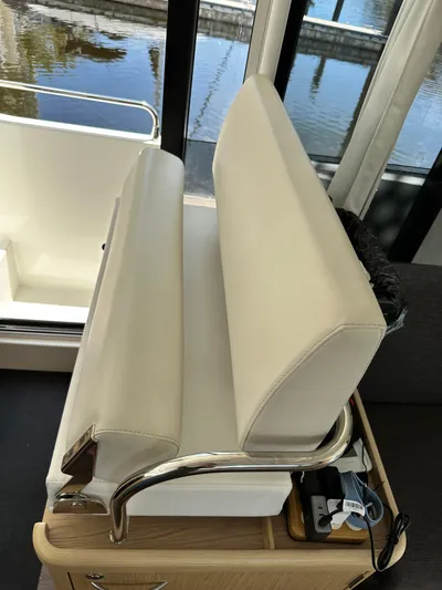 Oceans Edge Yacht Photos Pics Interior seating of 2022 Beneteau Swift Trawler 35, featuring white cushions and metal accents.