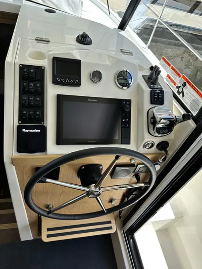 Oceans Edge Yacht Photos Pics 2022 Beneteau Swift Trawler 35 helm with Raymarine navigation system and steering wheel.