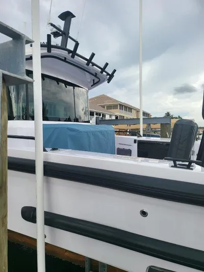  Yacht Photos Pics 2024 Axopar 37 XC CROSS CABIN boat docked under cloudy skies.