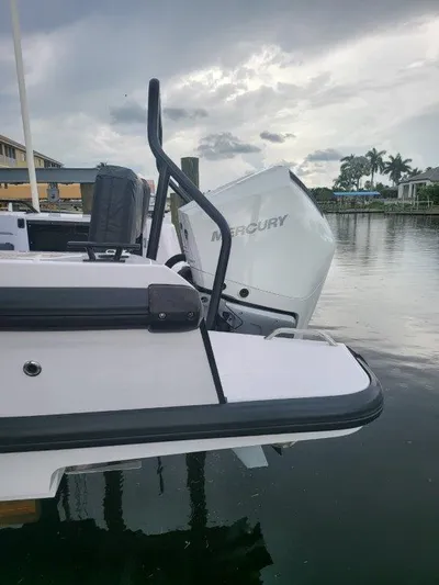  Yacht Photos Pics 2024 Axopar 37 XC CROSS CABIN with Mercury engine, docked by a serene waterfront.