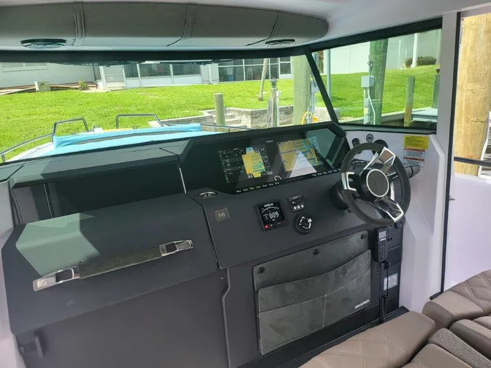  Yacht Photos Pics 2024 Axopar 37 XC CROSS CABIN helm with modern navigation displays and steering wheel.