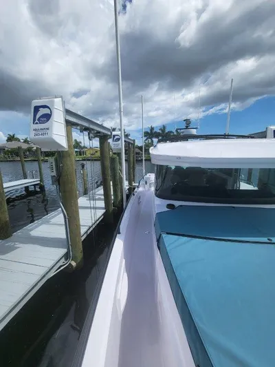  Yacht Photos Pics 2024 Axopar 37 XC CROSS CABIN docked under cloudy sky.