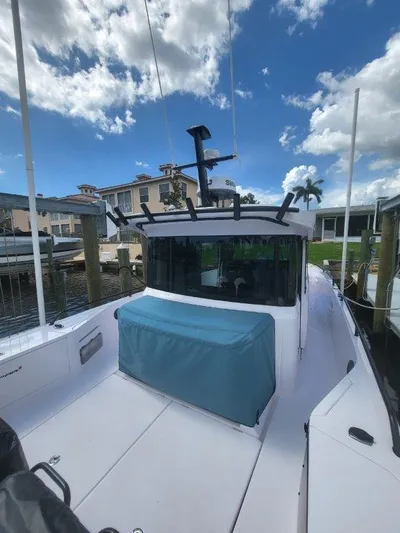  Yacht Photos Pics 2024 Axopar 37 XC CROSS CABIN boat docked under a blue sky.