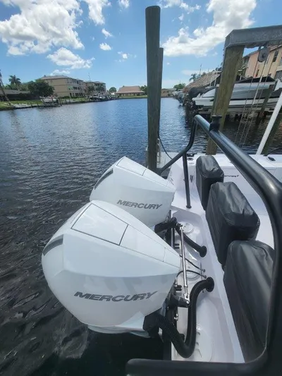  Yacht Photos Pics 2024 Axopar 37 XC CROSS CABIN with dual Mercury outboard engines docked by the water.