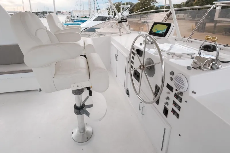 Masterplan Yacht Photos Pics Helm of 1975 Hatteras 58 Long Range Cruiser with white captain's chairs and navigation equipment.